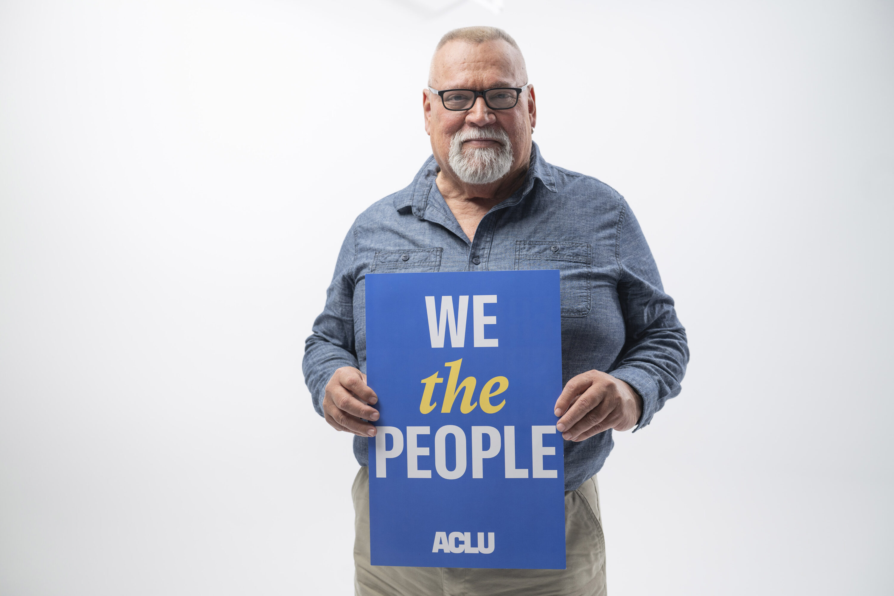 Tom Alonzo holds a photo that says We The People.
