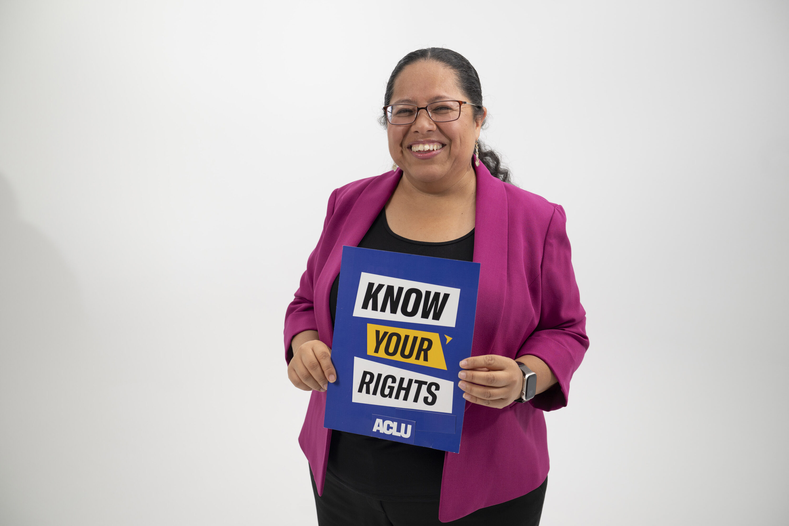Maribel Hernandez Rivera holds a sign that says Know Your Rights.