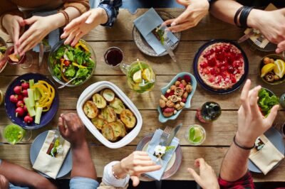 A group of people have an animated conversation over a dinner table.