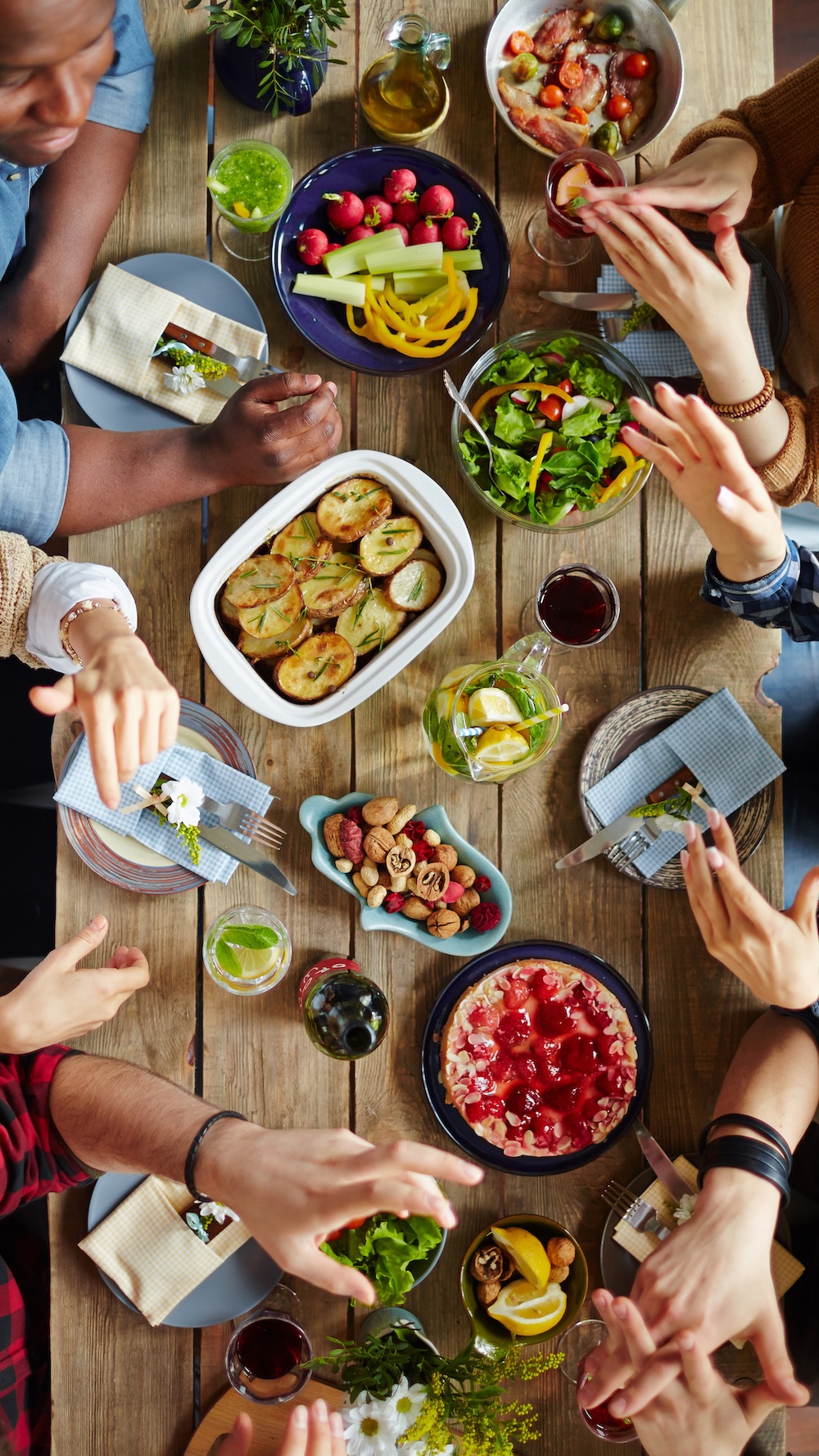 A group of people have an animated conversation over a dinner table.