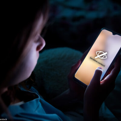 A child using smart phone in bed late at night.