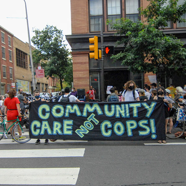 Protesters hold a banner calling for investment in communities, not the police