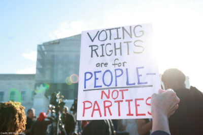 An individuals holding a sign saying "Voting Rights Are For People Not Parties," outside of the U.S. Supreme Court ahead of arguments in the Voting Rights case Callais v. Landry.