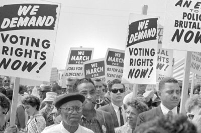 Protesters with signs at march on Washington, D.C. for Jobs and Freedom, carrying signs that read "WE DEMAND VOTING RIGHTS NOW!" and WE DEMAND AN END O POLICE BRUTALITY NOW!" on August 28, 1963.
